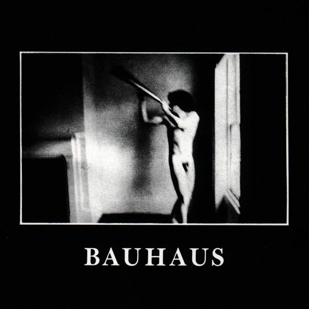 Album cover for Bauahua - In The Flat Field featuring a black and white album cover with a person holding a horn, featuring the word 'BAUHAUS'.