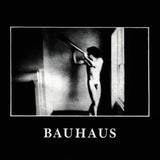 Album cover for Bauahua - In The Flat Field featuring a black and white album cover with a person holding a horn, featuring the word 'BAUHAUS'.