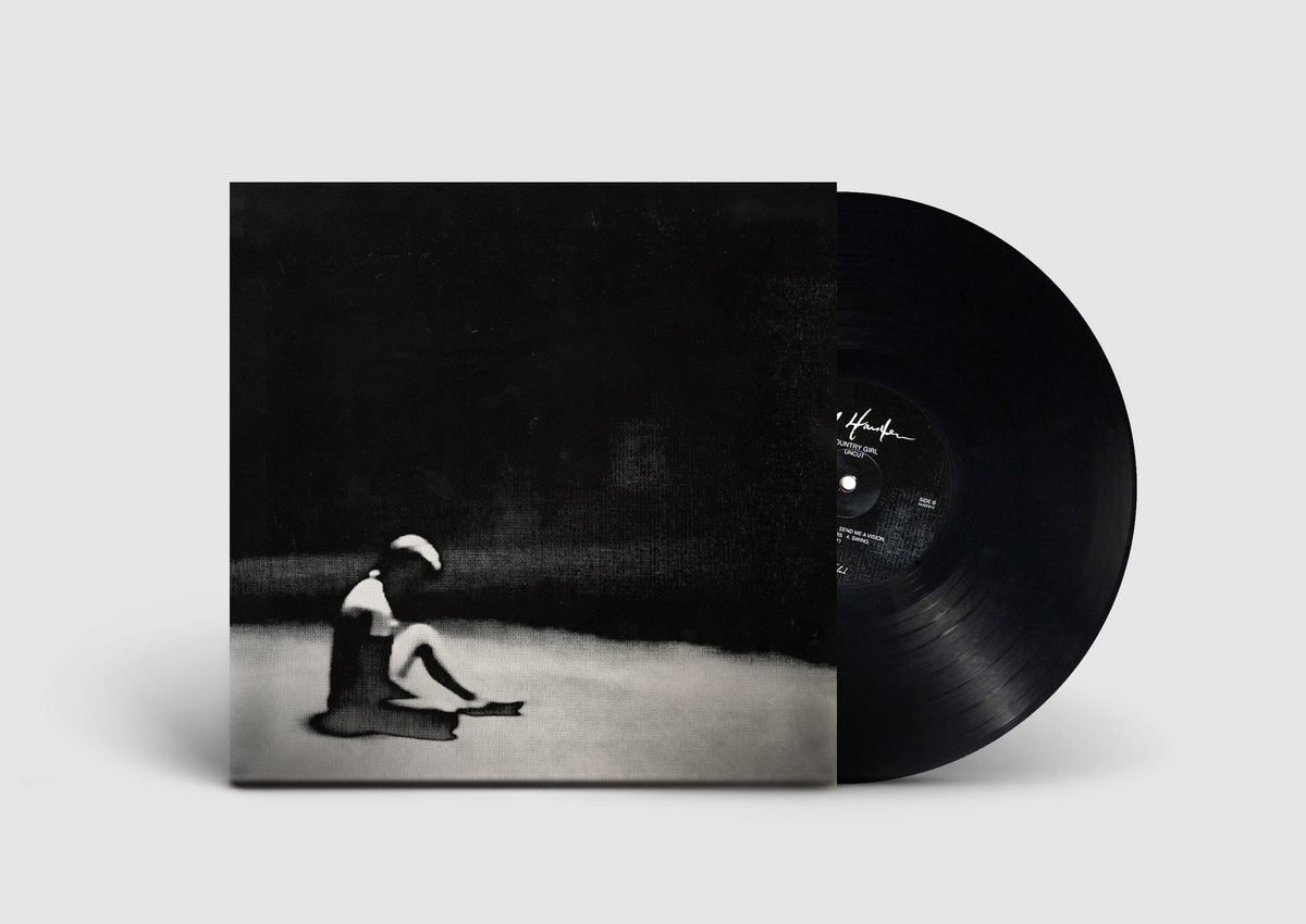 Vinyl record with cover featuring a black and white image of a person sitting on the ground.
