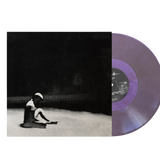Vinyl record with a purple disc and black cover featuring a person sitting on the ground.