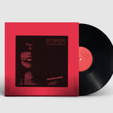 Vinyl record with red cover on a light gray background