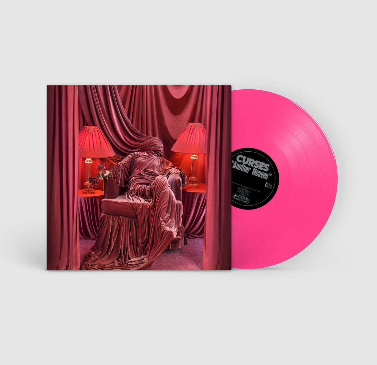 Vinyl record with pink disc and cover featuring a red curtain and chair design.