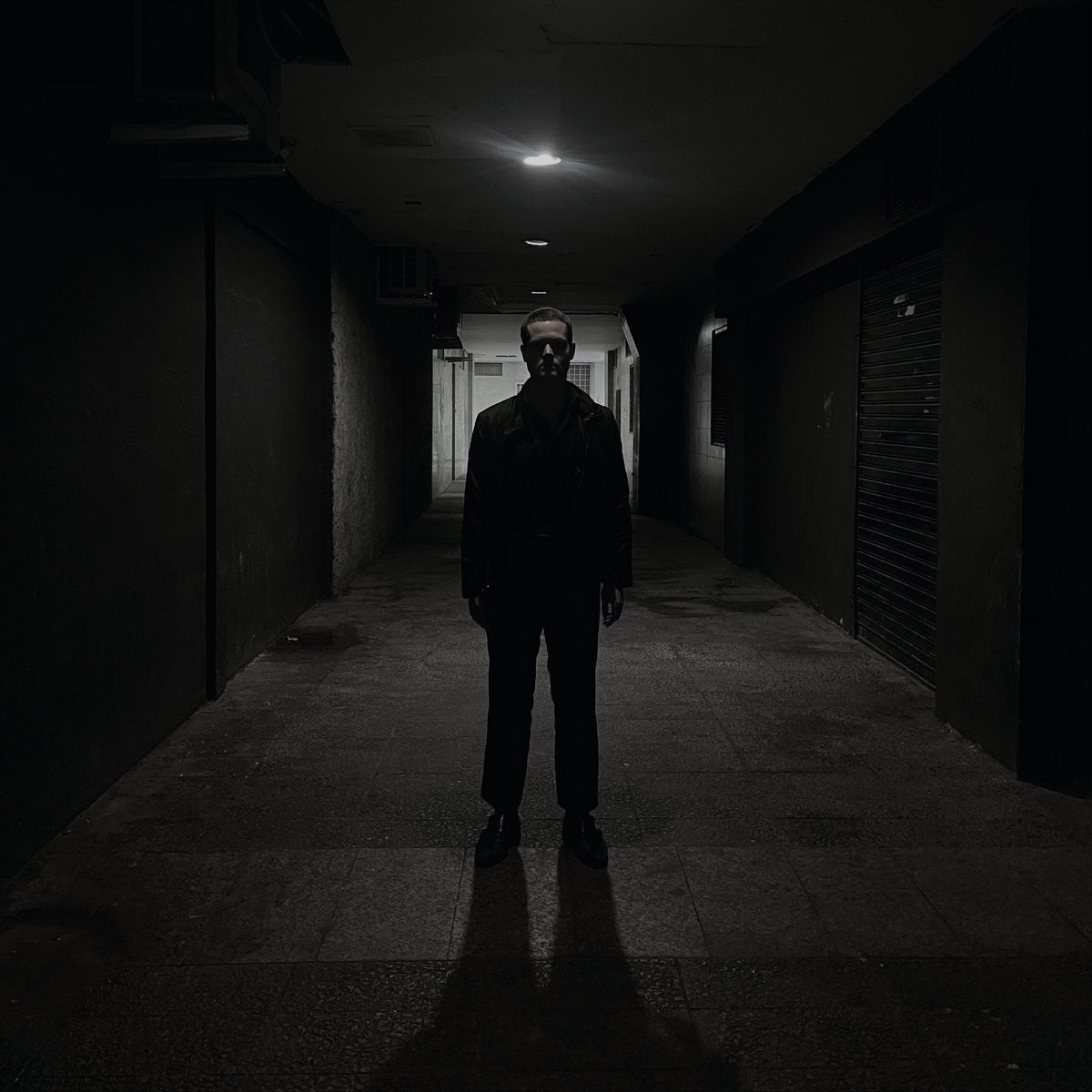 Album cover for Dancing Plague's "Domain" with a person standing in a dark alleyway with minimal lighting