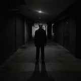 Album cover for Dancing Plague's "Domain" with a person standing in a dark alleyway with minimal lighting