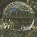Album cover for 'Spiral' by Darkside with a clear glass sphere with grass reflection on a natural background