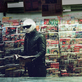 Album cover for Drab Majesty's "Modern Mirror" with a person in a black leather jacket and sunglasses standing in a magazine rack