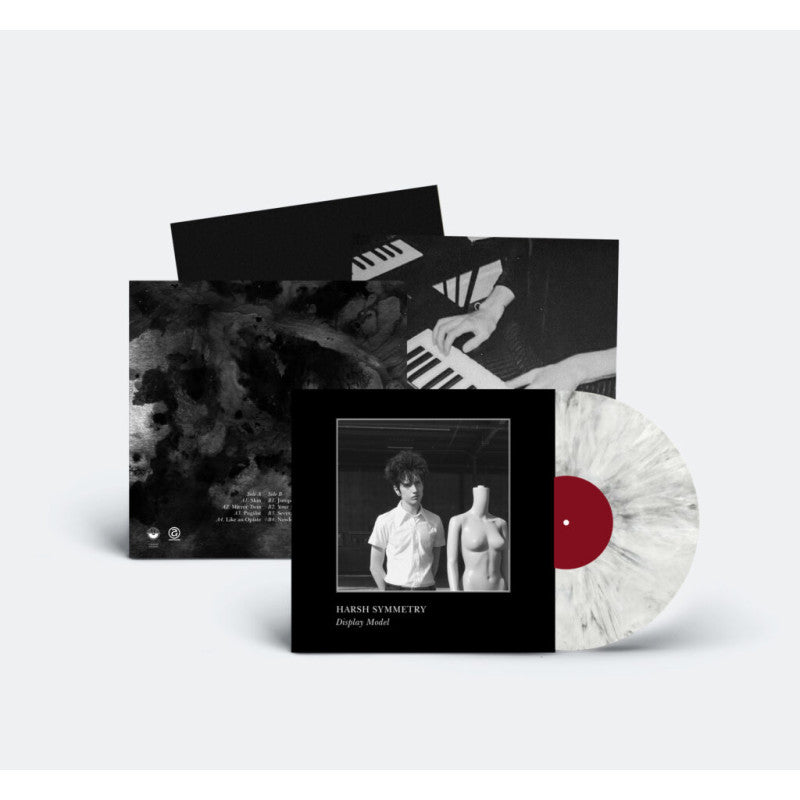 Vinyl record with a white label and black and white cover, featuring a person and abstract design.