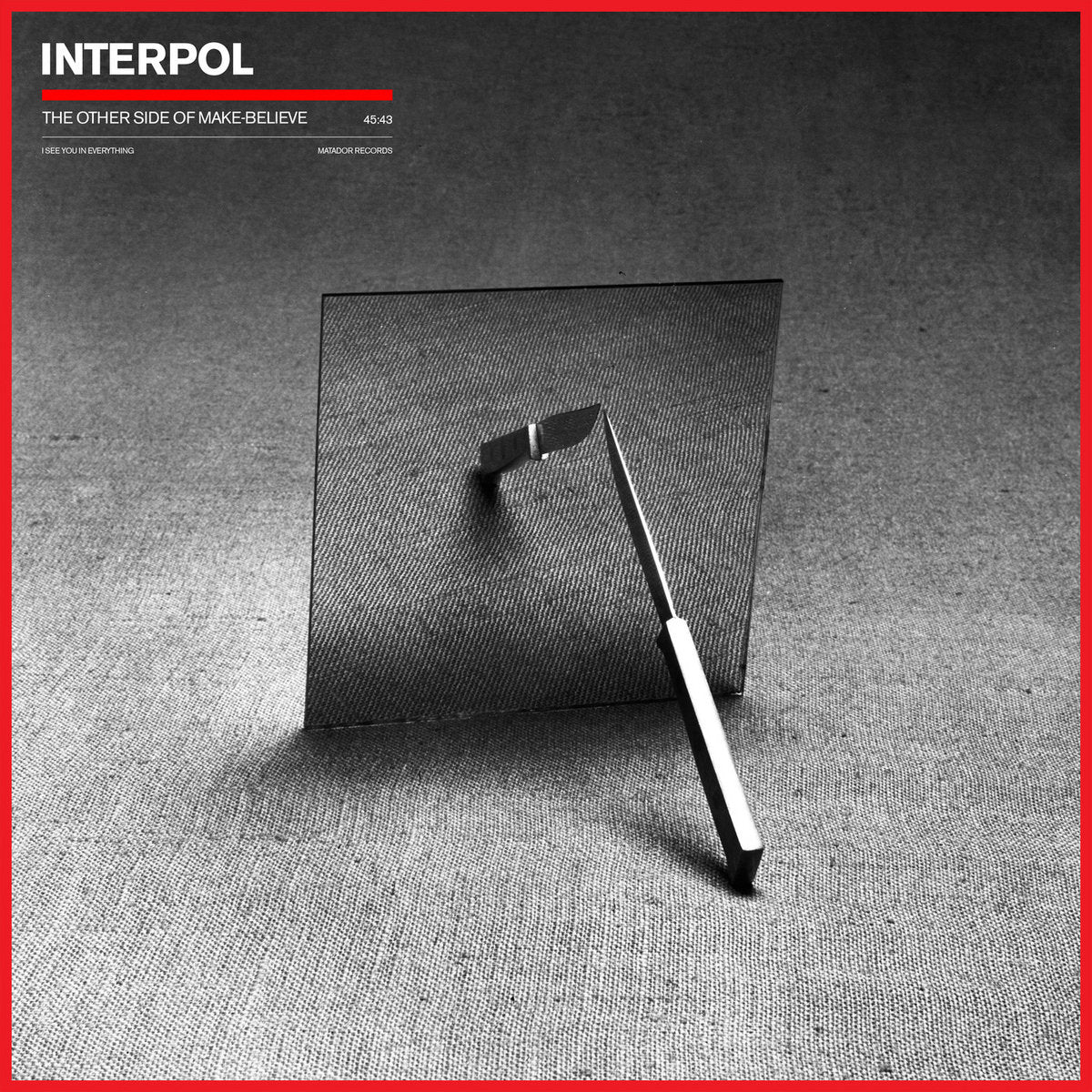 Album cover for Interpol's 'The Other Side of Make Believe' with a black and white photo and red border.