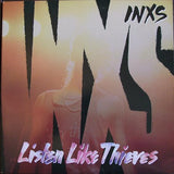 Album cover for INXS' 'Listen Like Thieves' with stylized text and silhouette.