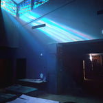 Album cover for 'Later Than You Think' by John Maus featuring a dark room with colorful light beams and stained glass window