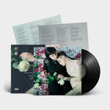 Vinyl record with a cover featuring two people and floral elements on a light gray background.