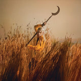 Album cover for Patrick Wolf's featuring a person in a yellow coat holding a large black tool in a field of tall grass with a warm, sepia-toned filter.