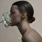 Album cover for Riki Gold showing a woman with a white flower near her face and a gold ear and earrings.