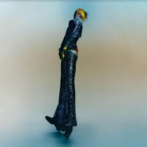 Album cover art for Yves Tumor - Praise A Lord Who Chews But Which Does Not Consume ( Or Simply Hot Between Worlds)  showing a person wearing a sparkly black outfit with a blurred background