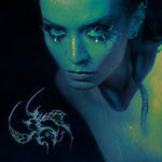 Album cover for Zanias Chrysalis showing a close-up of a woman's face with a glowing blue hue, featuring a dragon design on a dark background.