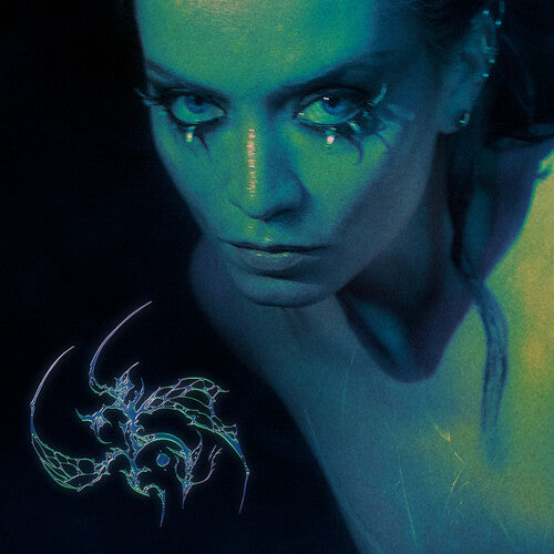 Album cover for Zanias Chrysalis showing a close-up of a woman's face with a glowing blue hue, featuring a dragon design on a dark background.