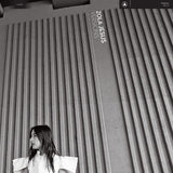 Album cover with a person sitting against a textured wall, featuring 'Zola Jesus * Versions' text.
